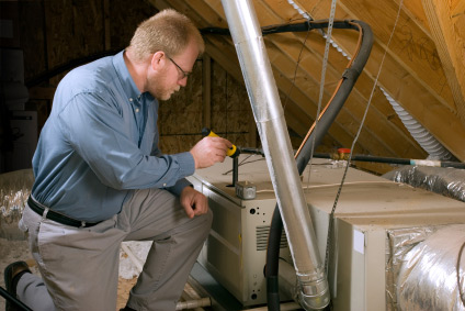 Technician working on an air handler in an attic.